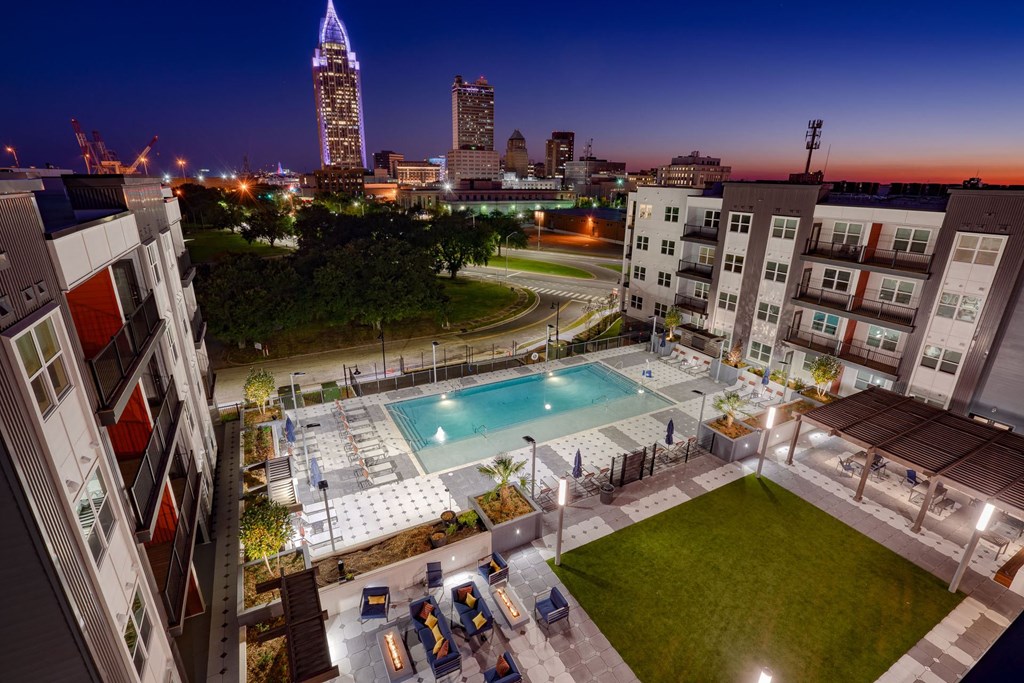an aerial view of a pool at night with the city of tampa in the