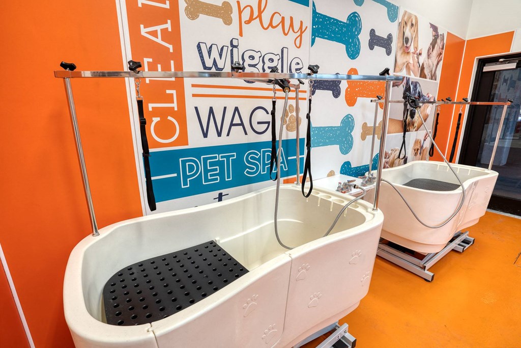 a bathroom with a tub and a toilet and a wall with play wiggles