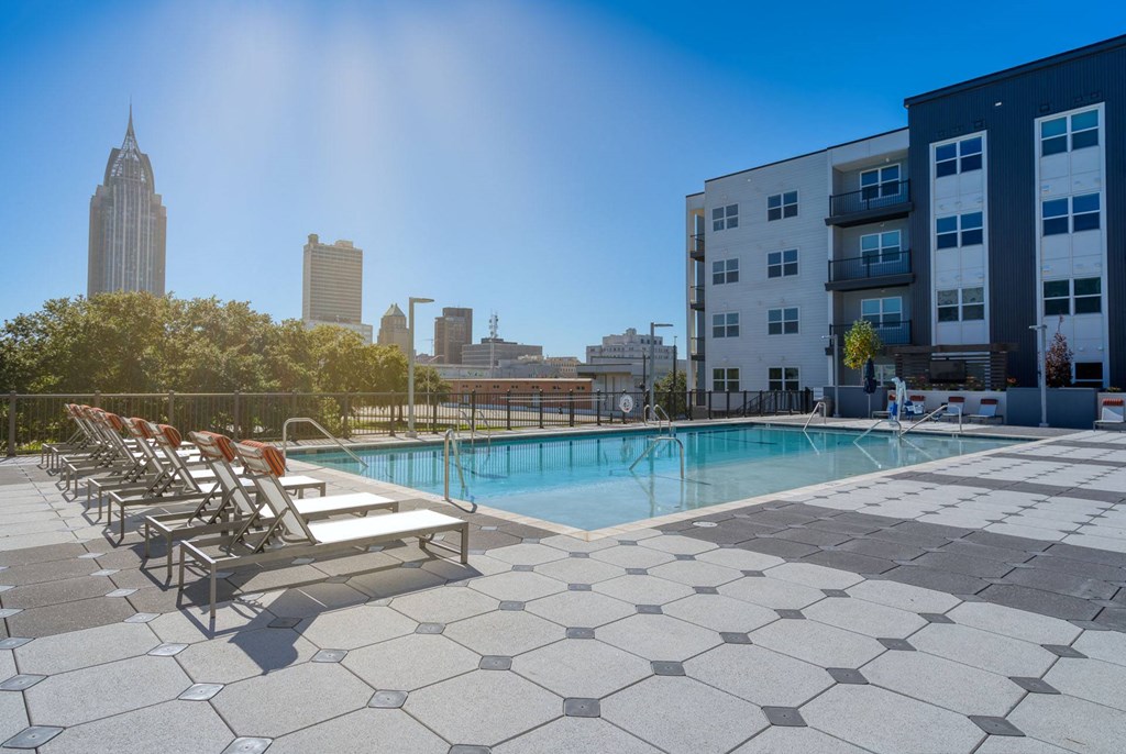 a swimming pool with a city skyline in the background