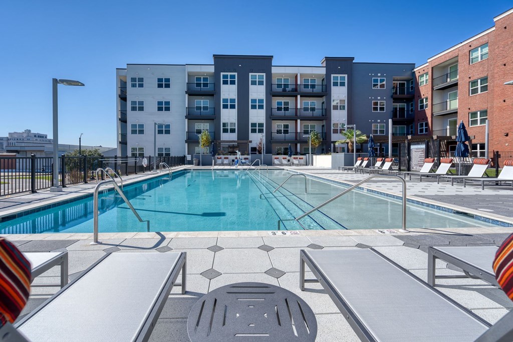 a swimming pool with an apartment building in the background