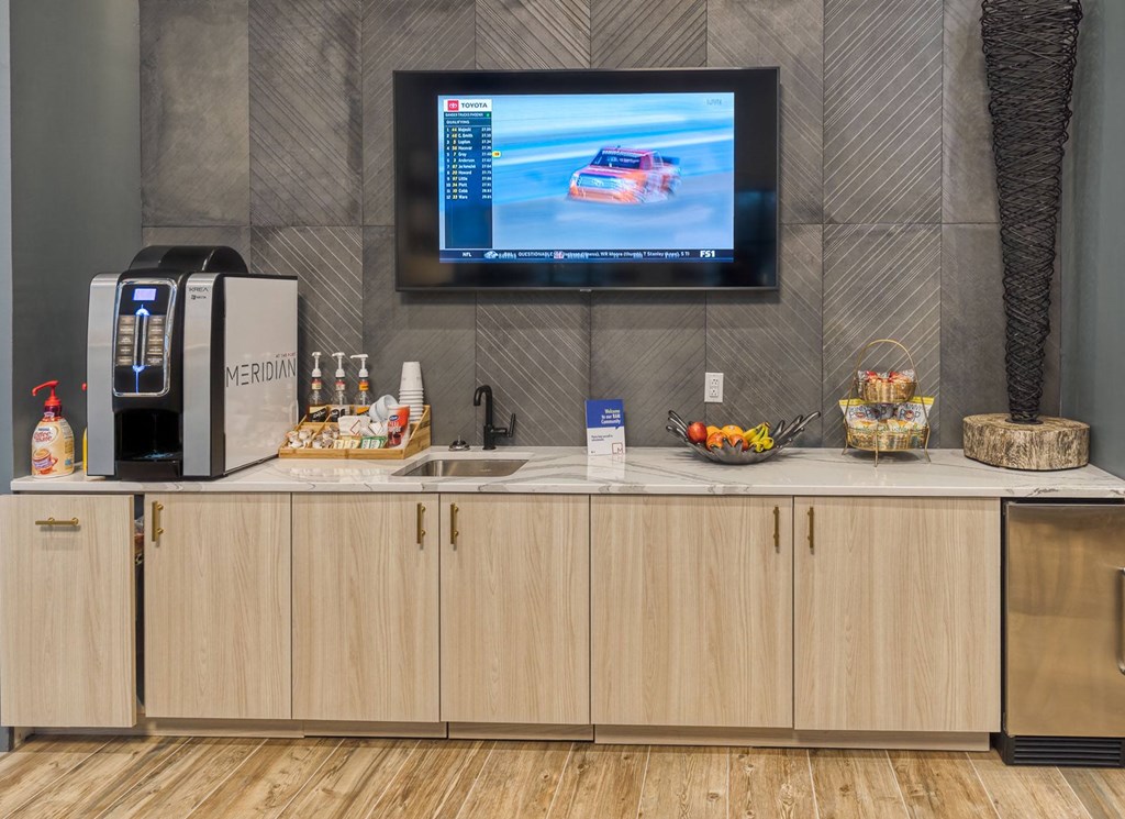 a kitchen with a sink and a television on the wall