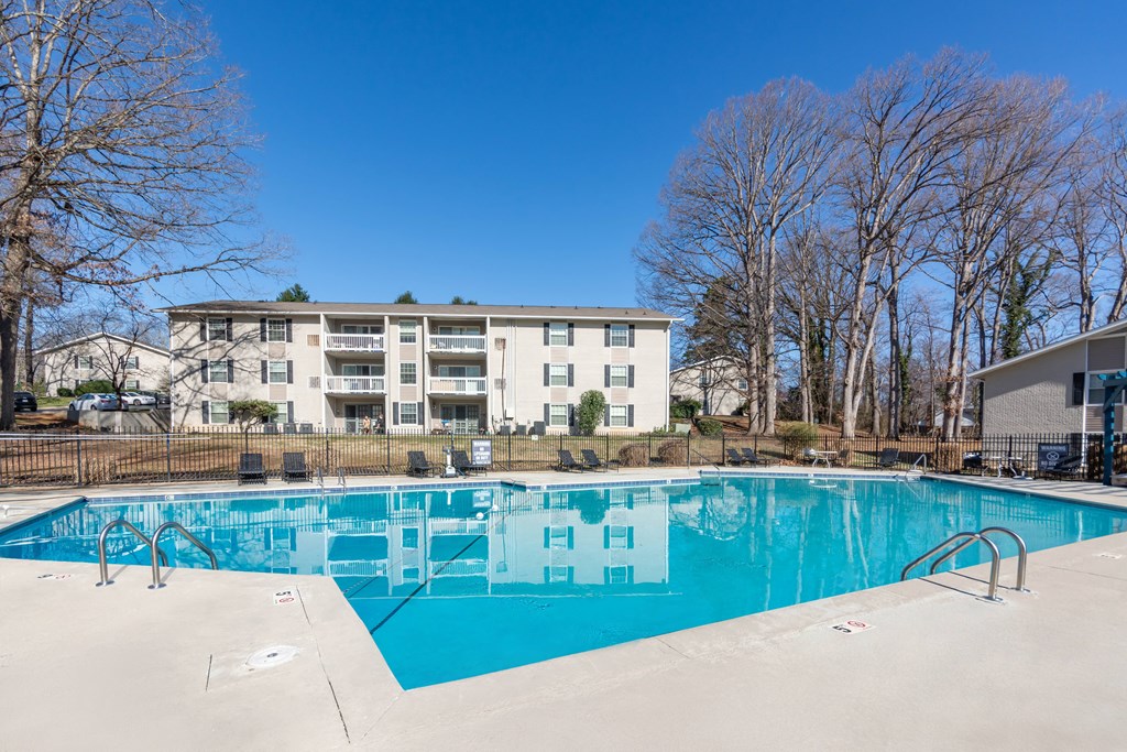 A large swimming pool in front of an apartment complex at Madison Woods apartments in Greensboro, NC.