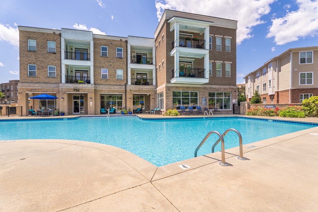 a swimming pool with an apartment building in the background