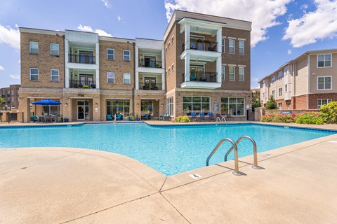 a swimming pool with an apartment building in the background