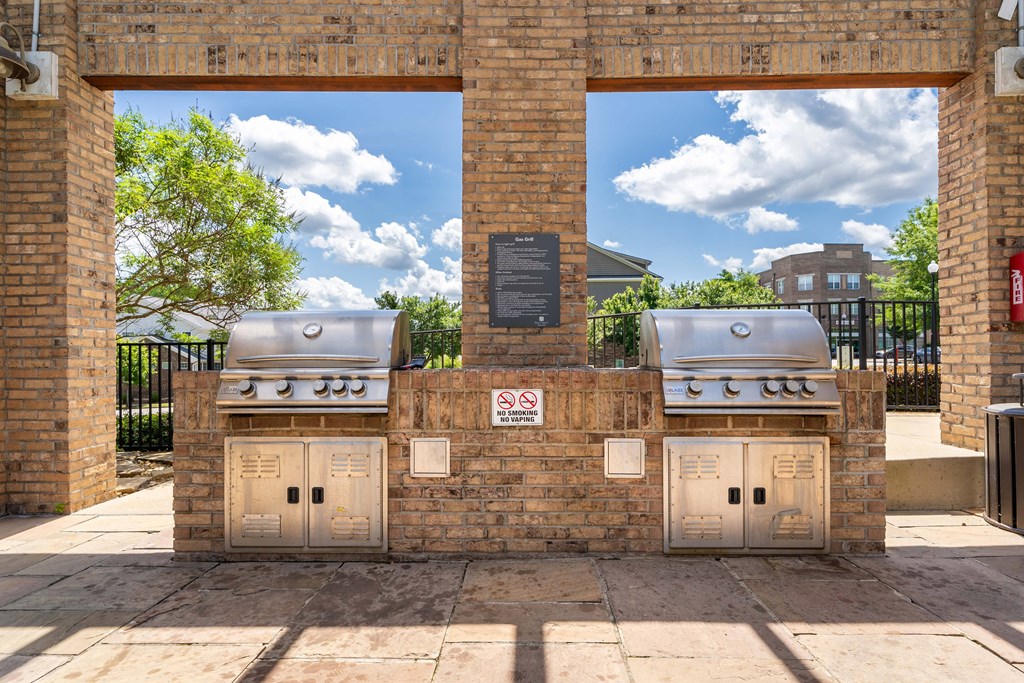 two bbq pits on the side of a brick building
