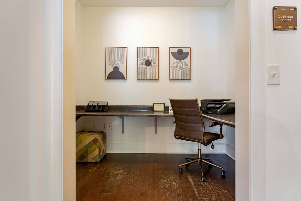 a room with a desk and a chair and paintings on the wall
