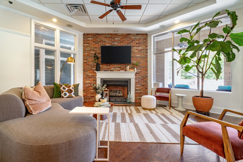 a living room with furniture and a brick fireplace