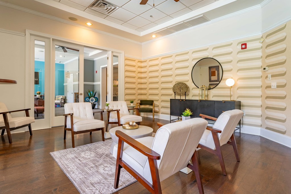a living room with a table and chairs and a mirror