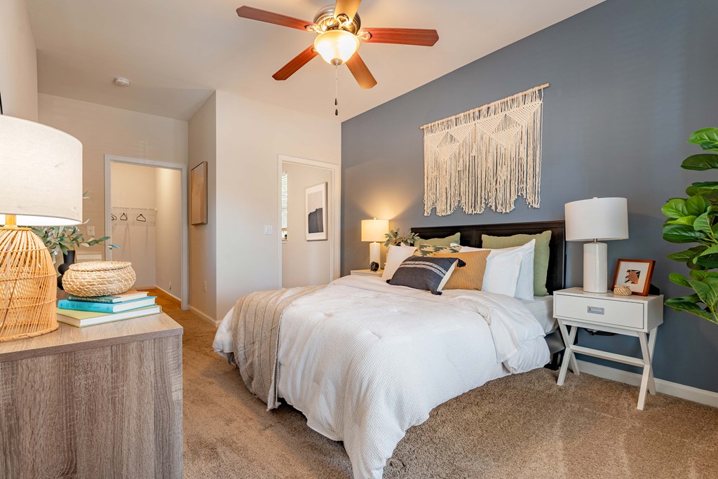 a bedroom with a large bed and a ceiling fan