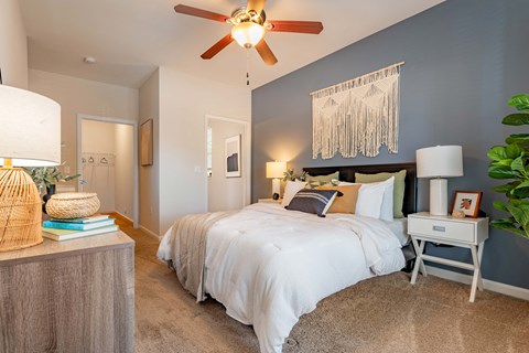 a bedroom with a large bed and a ceiling fan
