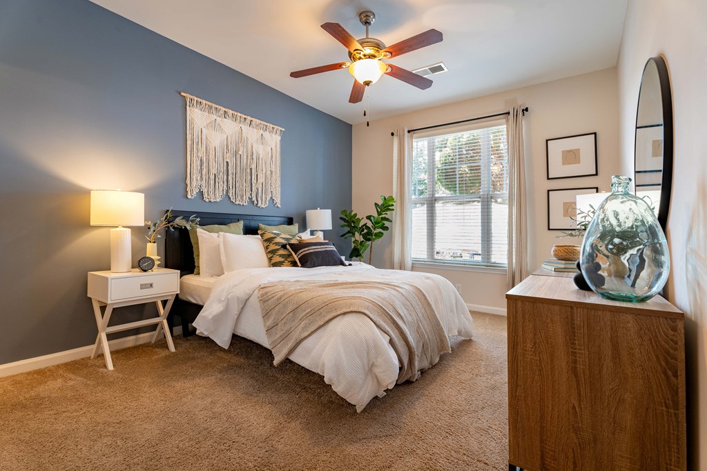 a bedroom with a large bed and a ceiling fan
