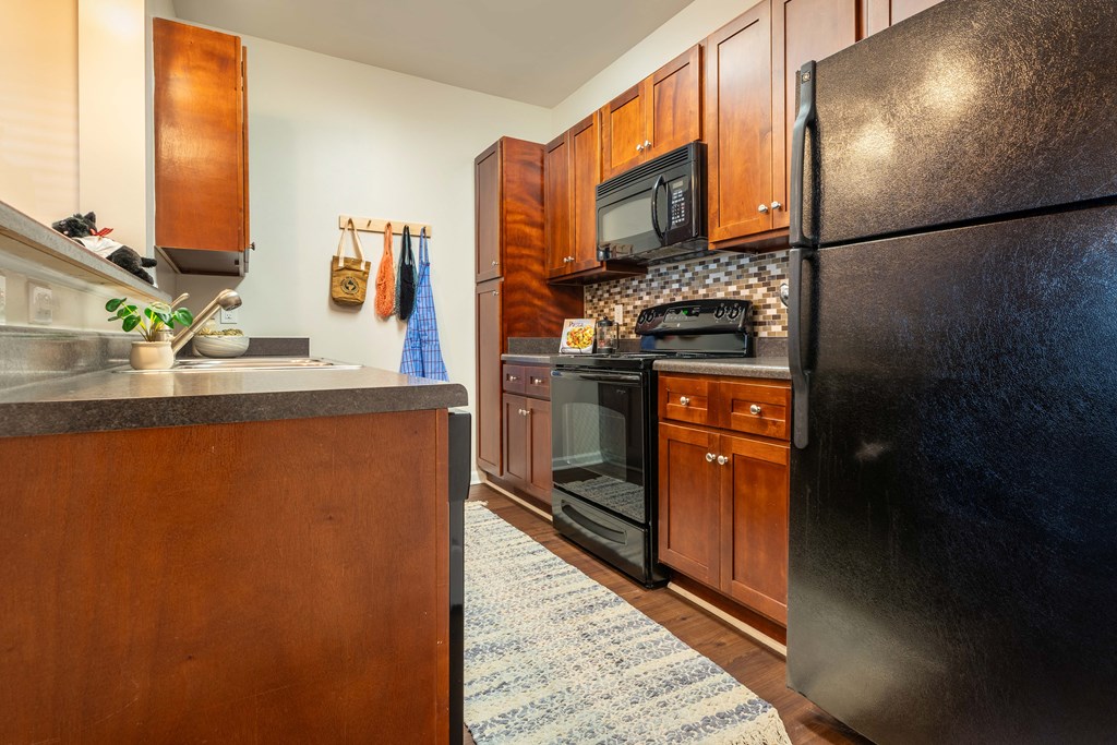 a kitchen with black appliances and wood cabinets
