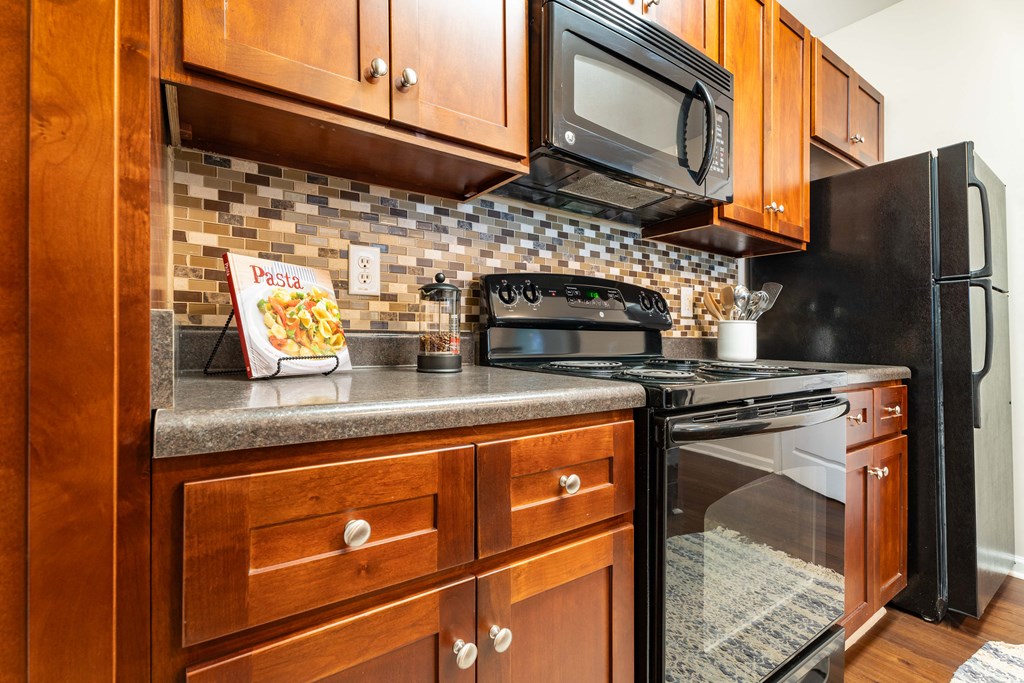 a kitchen with a stove and a microwave and wooden cabinets