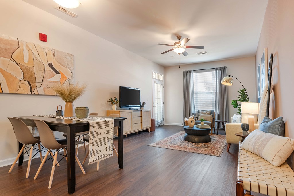 a living room with a dining room table and a ceiling fan