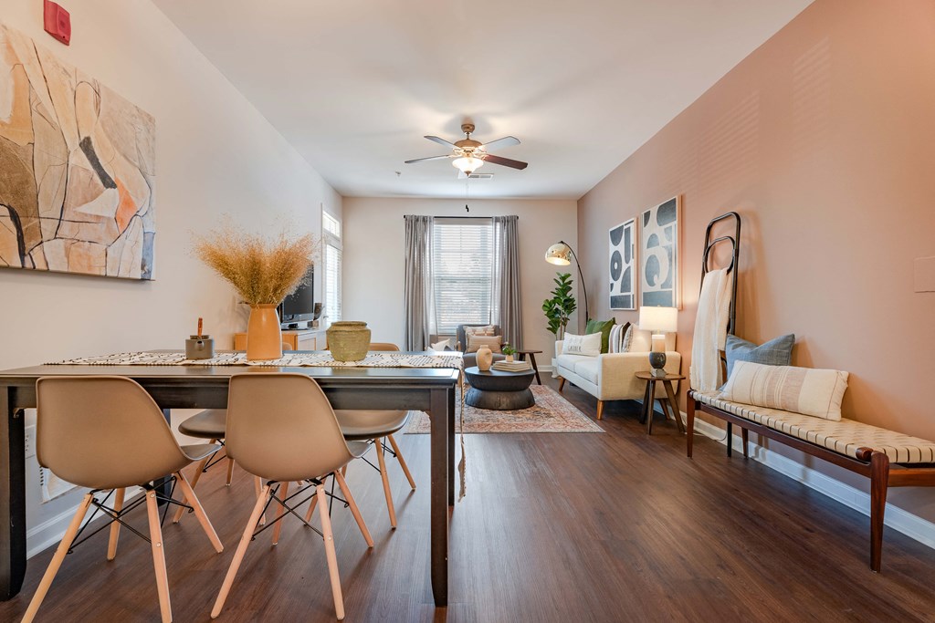 a living room with a dining room table and a ceiling fan