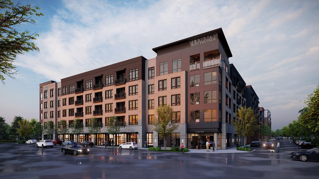 A modern apartment building with cars parked in front.