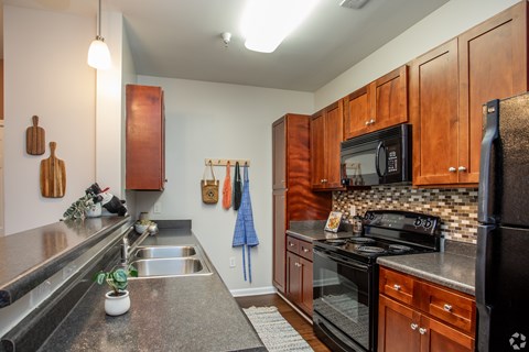 A kitchen with wooden cabinets and black appliances.