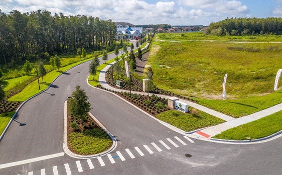 an aerial view of a road and a park with trees