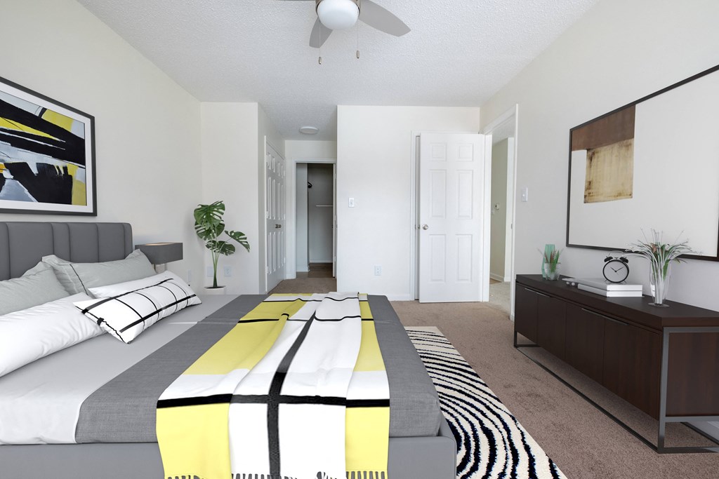 a bedroom with a large bed and a ceiling fan