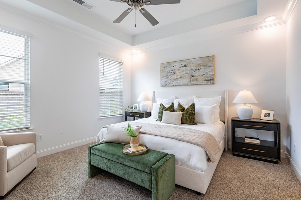 a bedroom with a large bed and a ceiling fan