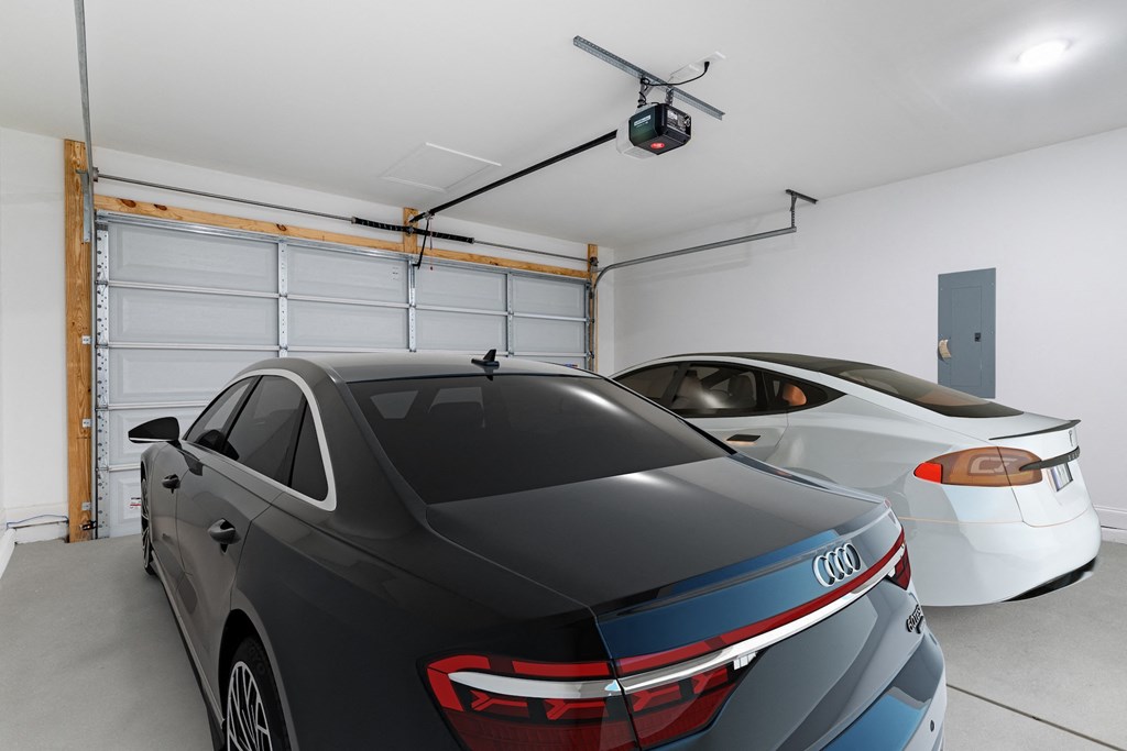 two cars parked in a garage with a projector screen on the wall