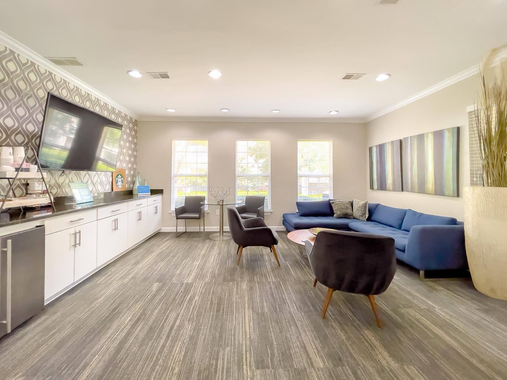 a living room with a couch and chairs and a tv