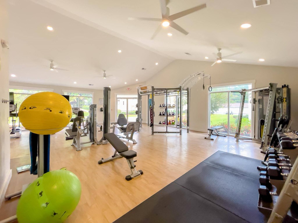 a home gym with weights and a ceiling fan