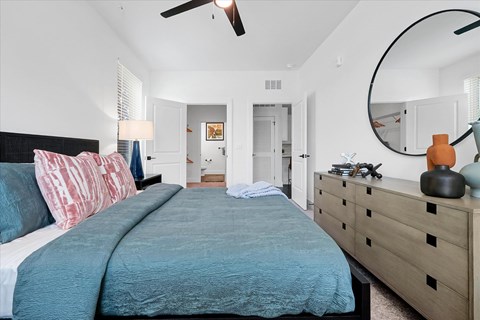 A bedroom with a large bed and a dresser.