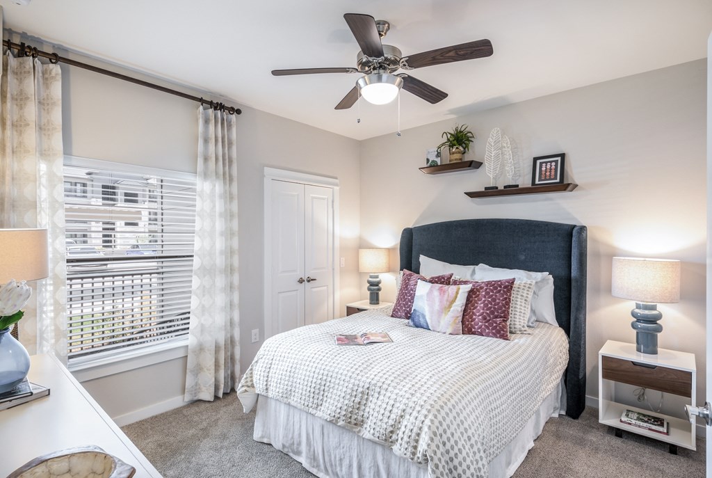 a bedroom with a bed and a ceiling fan