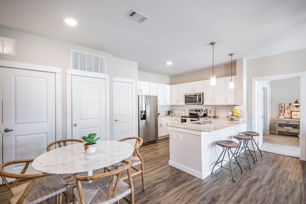 a kitchen and dining area with a marble table and chairs
