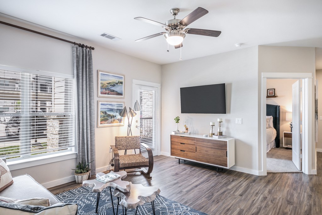 a living room with a ceiling fan and a tv
