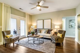 a living room with green walls and a ceiling fan
