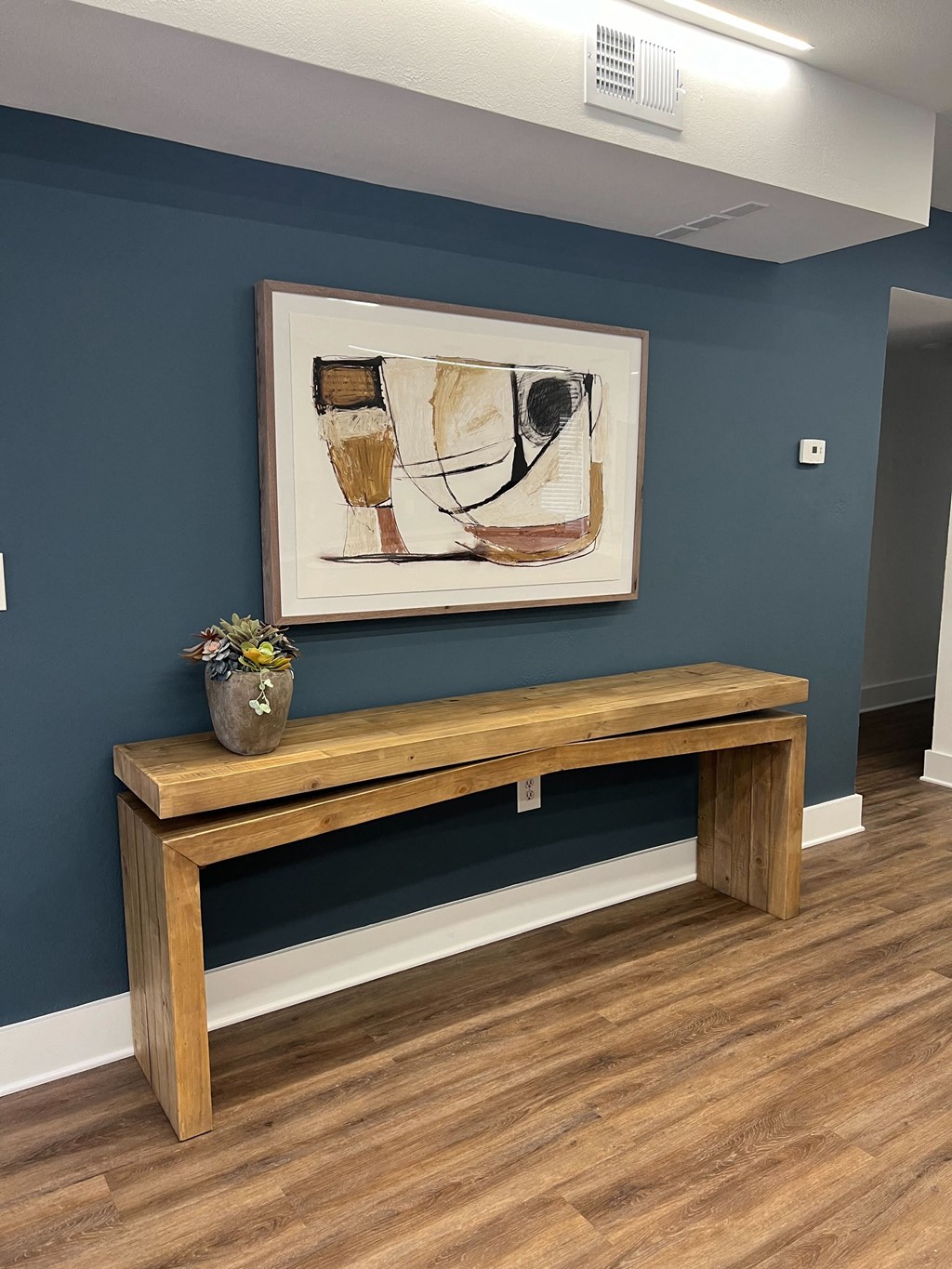 a bench in a room with a painting on the wall