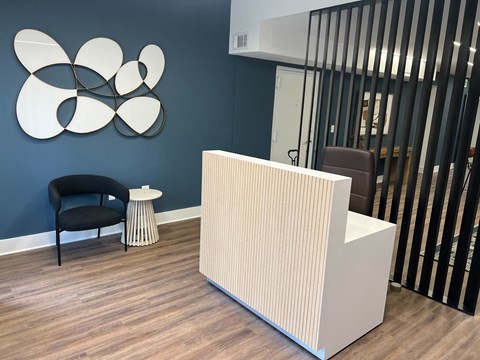a reception area with a white radiator and a black chair and a blue wall with