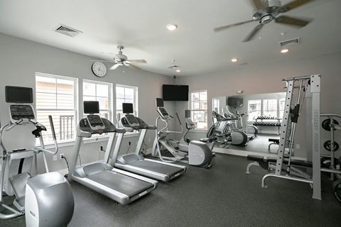 A spacious gym with treadmills, elliptical machines and other exercise equipment.