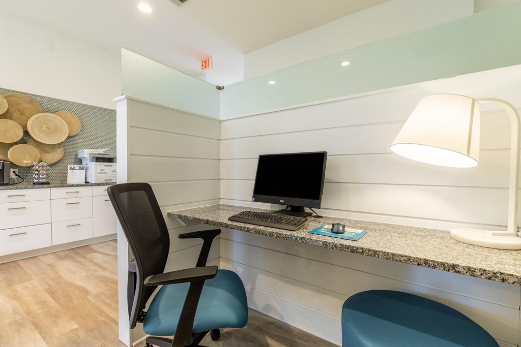 a desk with a computer and a chair in a room