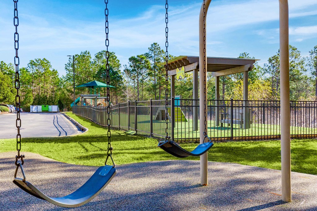 a swing set with two swings and a pavilion in the background