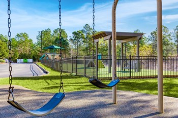 a swing set with two swings and a pavilion in the background - Photo Gallery 57