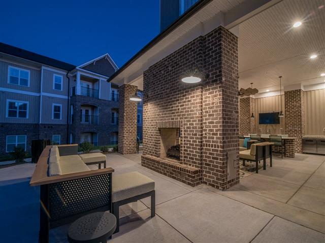 a patio with a fireplace and tables and chairs