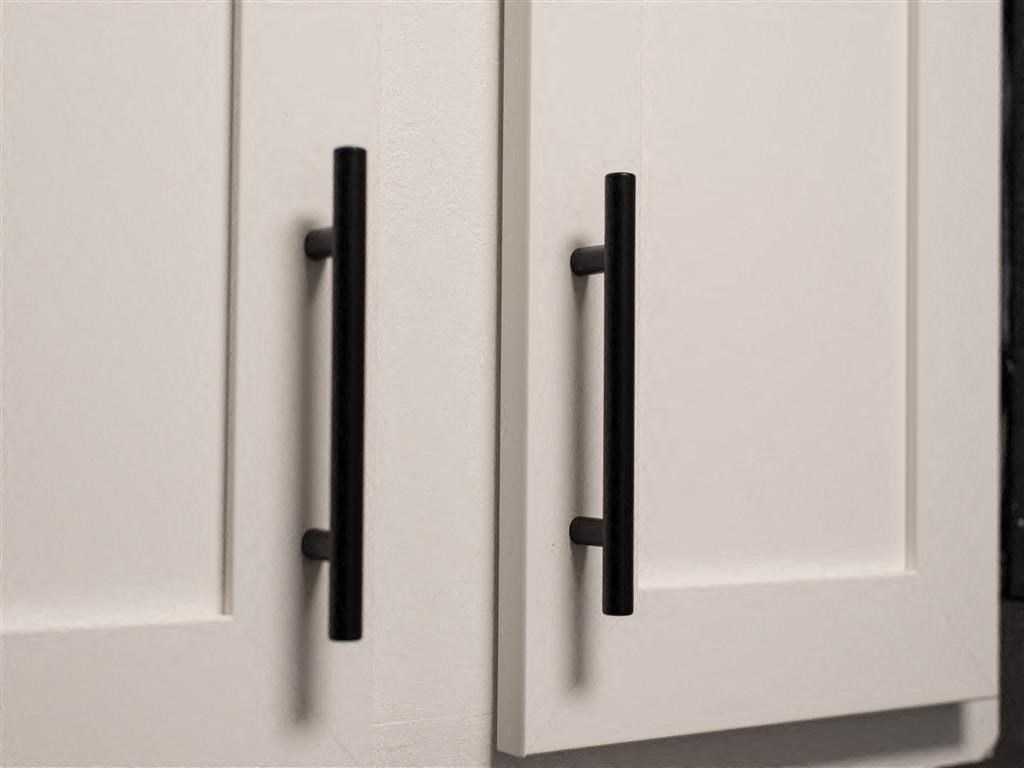 a white cabinet with black handles on it