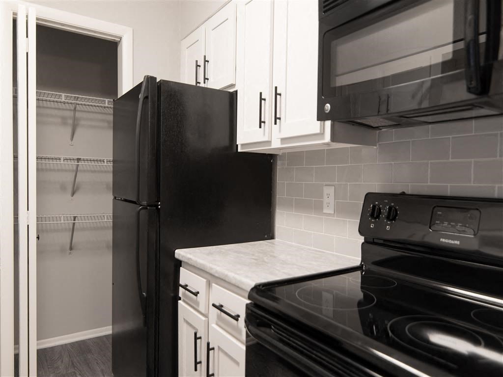 a kitchen with black appliances and white cabinets