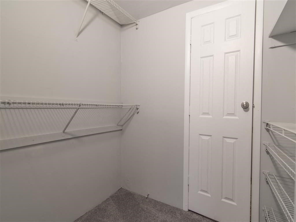 a closet in a white room with a white door