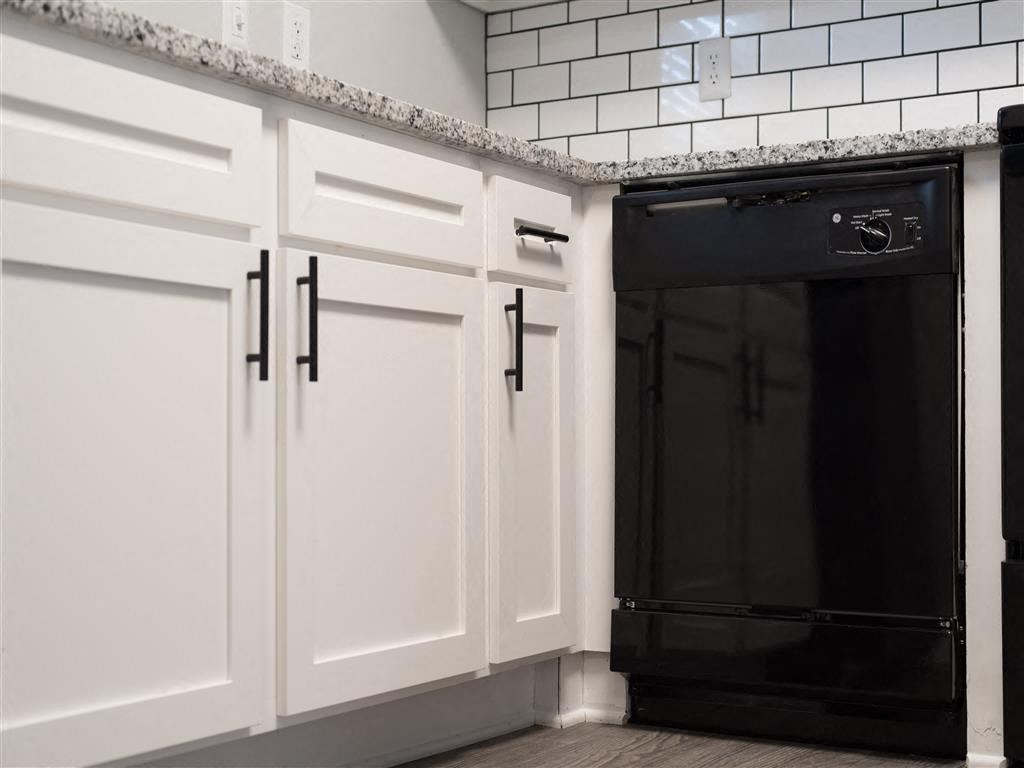 a kitchen with white cabinets and a black oven