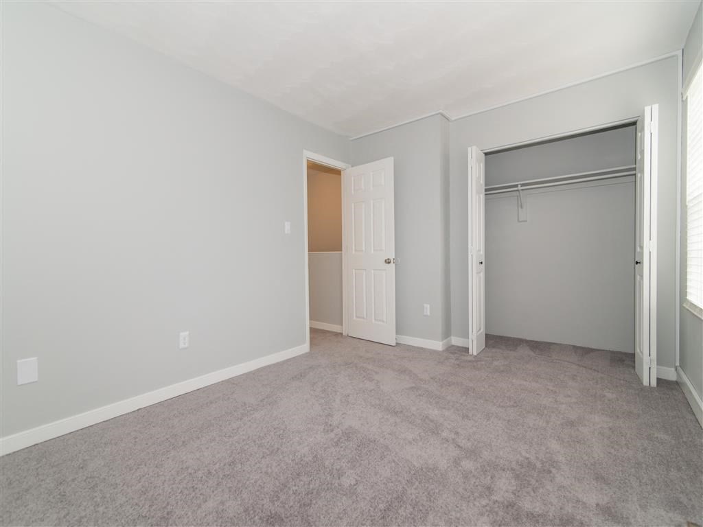 an empty living room with a door to a closet