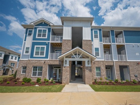 an apartment building with a sidewalk in front of it
