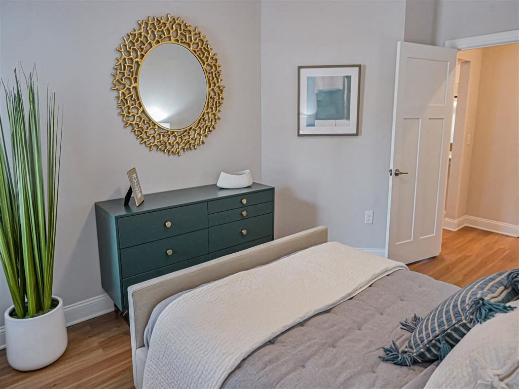 a bedroom with a bed and a dresser and a mirror