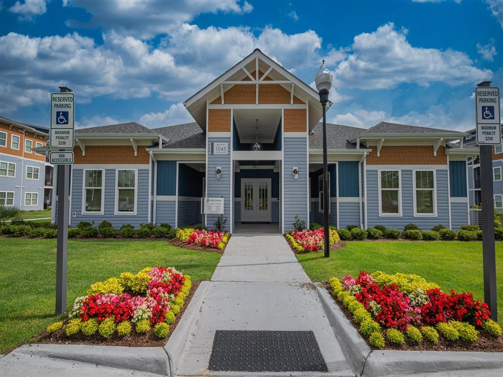 a building with a sidewalk and flowers in front of it