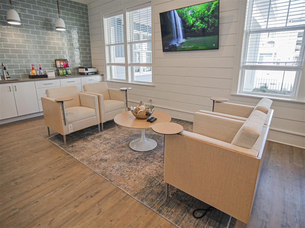 a living room with chairs and a table and a television