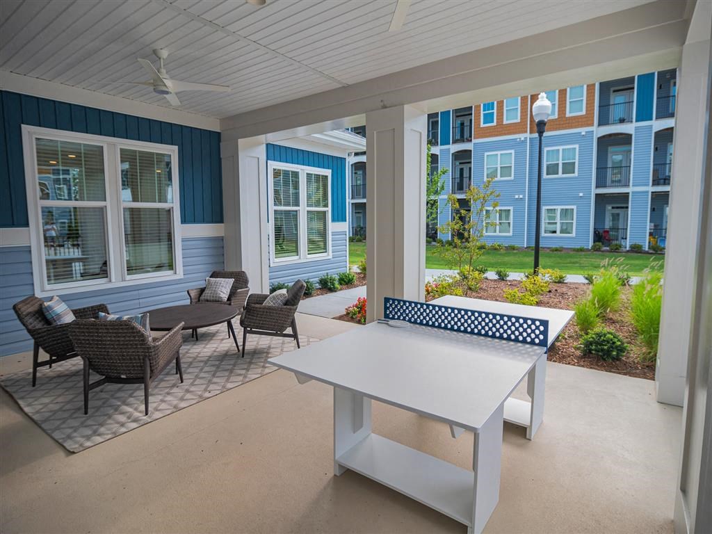 a covered patio with a table and chairs