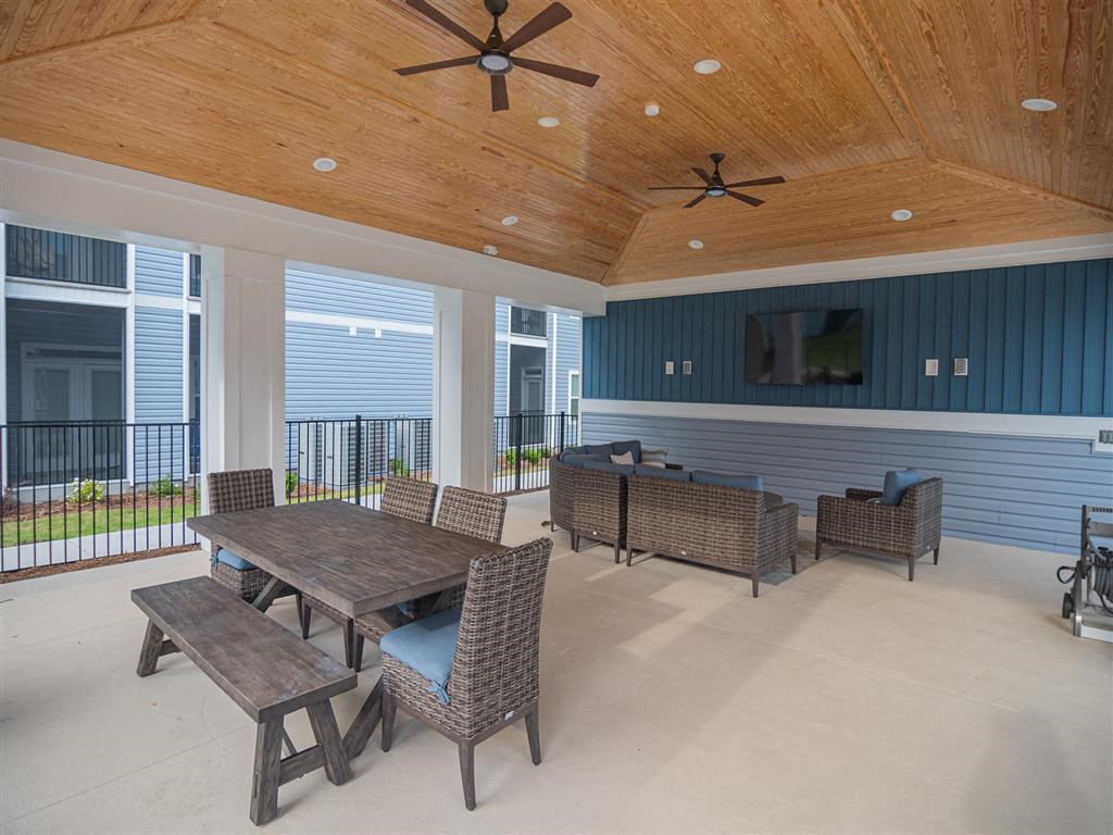 a covered patio with a table and chairs and a tv